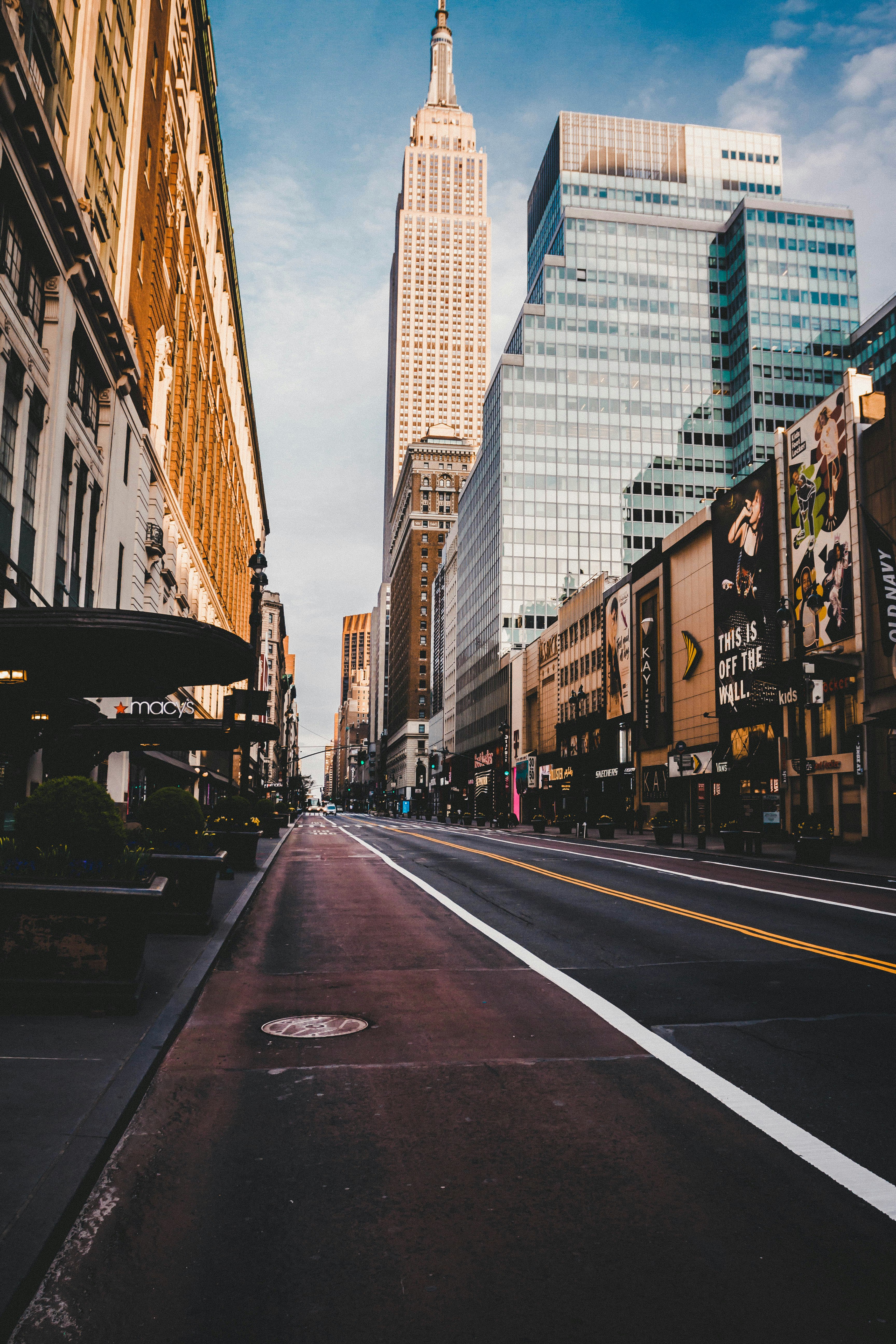 gray concrete road between high rise buildings during daytime